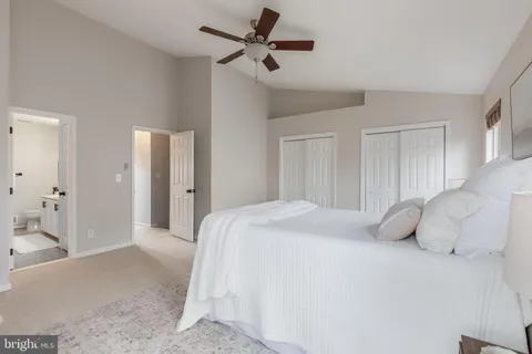 a bedroom with a bed and a ceiling fan