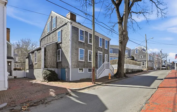 a view of a brick house with many windows next to a road