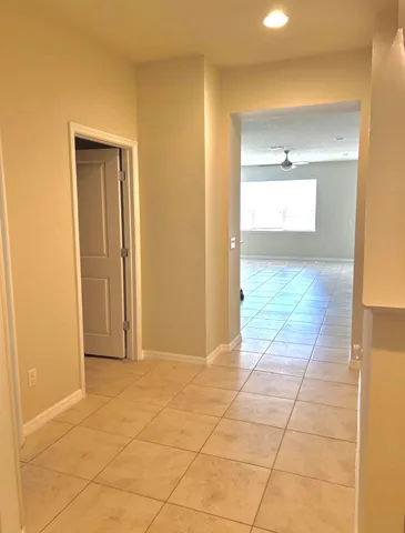 a view of hallway with a large window and a bathroom