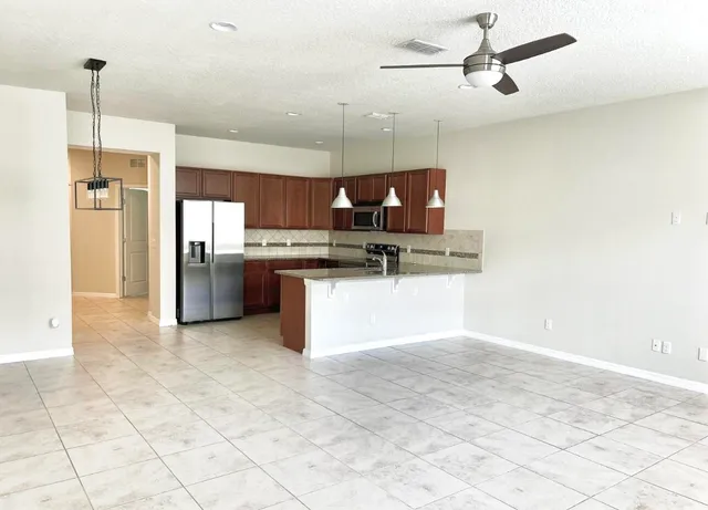 a kitchen with stainless steel appliances granite countertop a stove a sink and a refrigerator