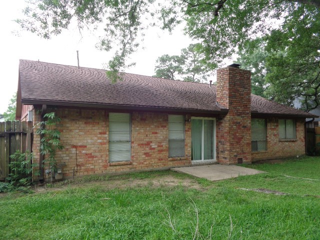 9530 Magnolia Ridge Drive Houston, TX 77070 - Photo 5 of 20 a view of a brick house with a small yard and a large tree