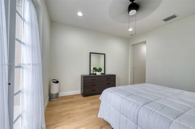 a spacious bedroom with a bed and a dresser