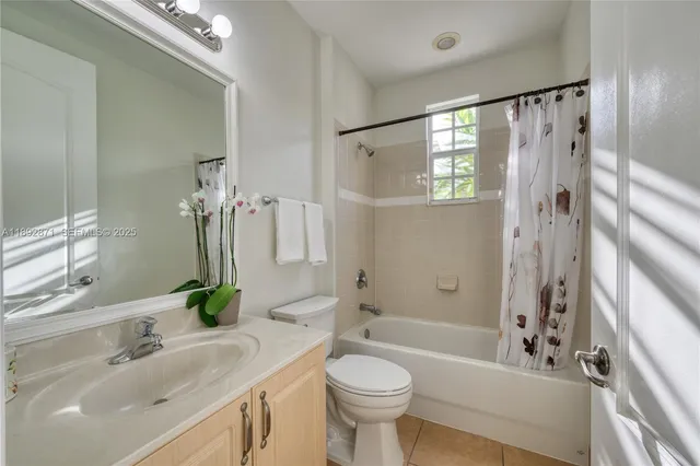 a bathroom with a sink a toilet a mirror a bathtub and shower