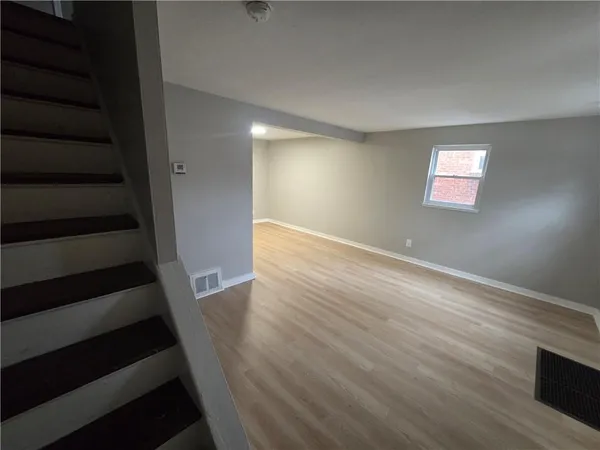 wooden floor in an empty room with stairs