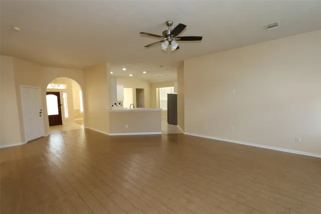 a view of a livingroom with a ceiling fan and wooden floor