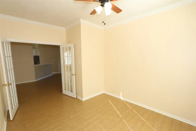 an empty room with a ceiling fan and carpet