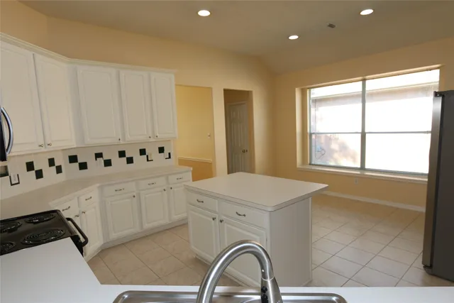 a kitchen with granite countertop a stove a sink and a microwave