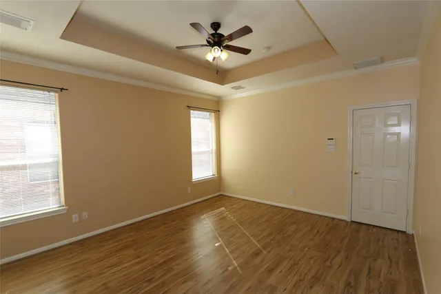 a view of an empty room with a window and wooden floor
