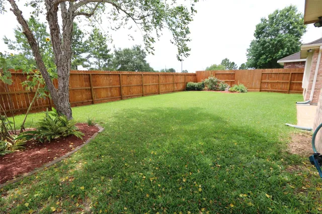 a view of backyard with wooden fence
