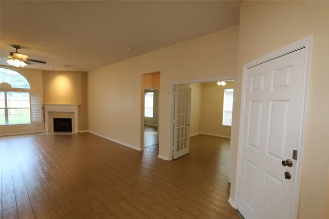 an empty room with wooden floor and fireplace