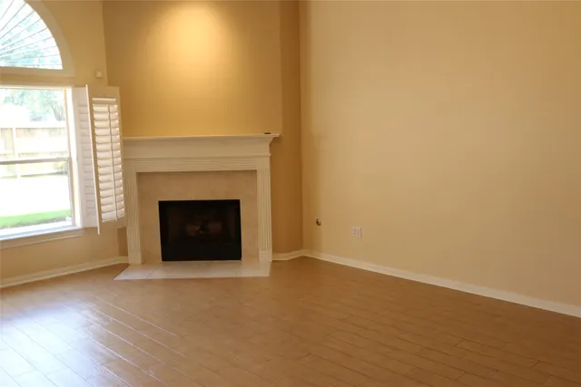 an empty room with a fireplace and window