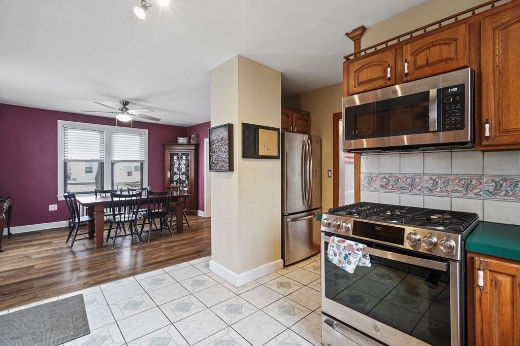 53 Pond Street Canton, MA 02021 - Photo 12 of 31 a kitchen with granite countertop a stove a microwave a dining table and chairs