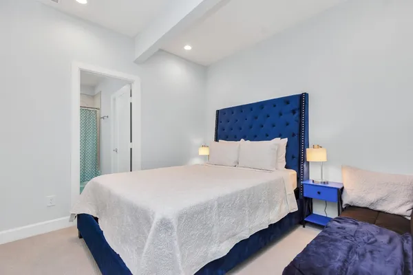 a large bed sitting in a bedroom next to a lamp