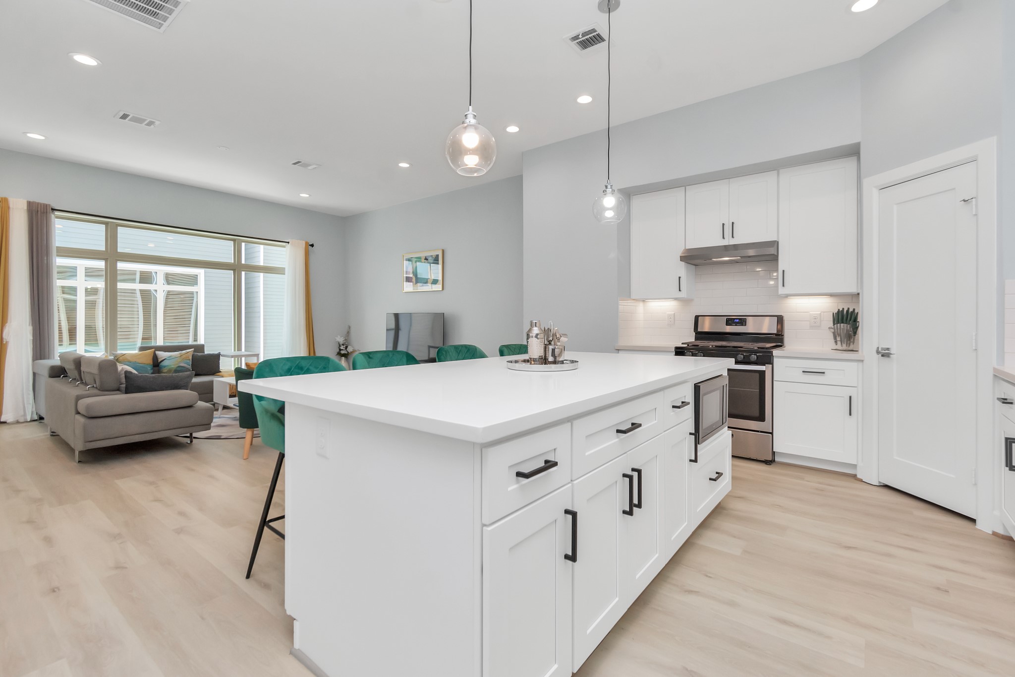 3310 Pease Street, Unit B Houston, TX 77003 - Photo 22 of 50 a kitchen with stainless steel appliances sink stove and white cabinets with wooden floor