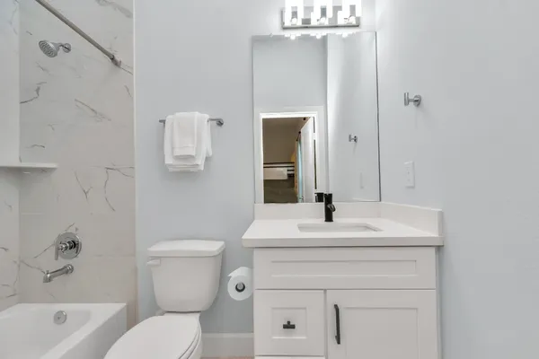 a bathroom with a sink a toilet and shower