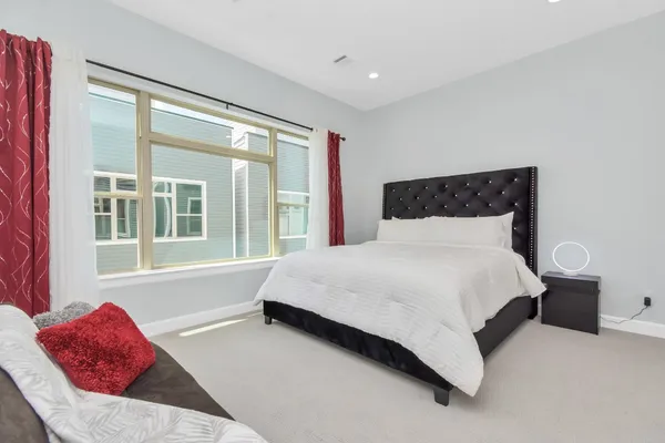 a bedroom with a large bed and a window