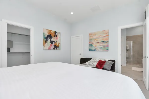 a bedroom with a large bed and a large mirror