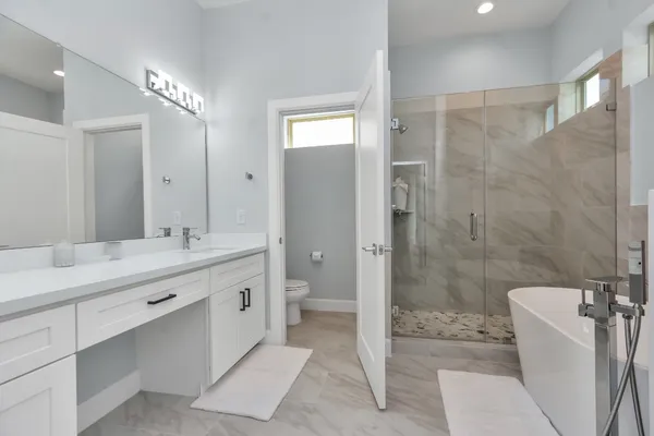 a bathroom with a double vanity sink toilet and shower