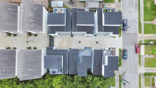 an aerial view of residential houses with outdoor space and parking
