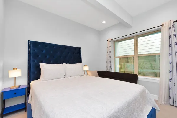 a bedroom with a large bed and a large window