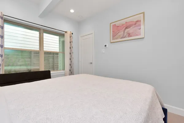 a large bed sitting in a bedroom next to a window