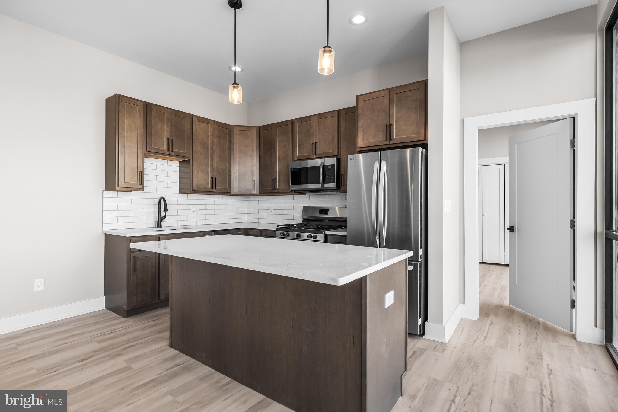 400 South Conkling Street, Unit 4 Baltimore, MD 21224 - Photo 4 of 18 a kitchen with stainless steel appliances a sink stove refrigerator and cabinets