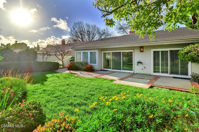 front view of a house with a yard and potted plants