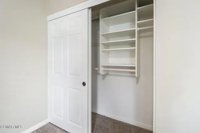 a view of walk in closet with empty racks