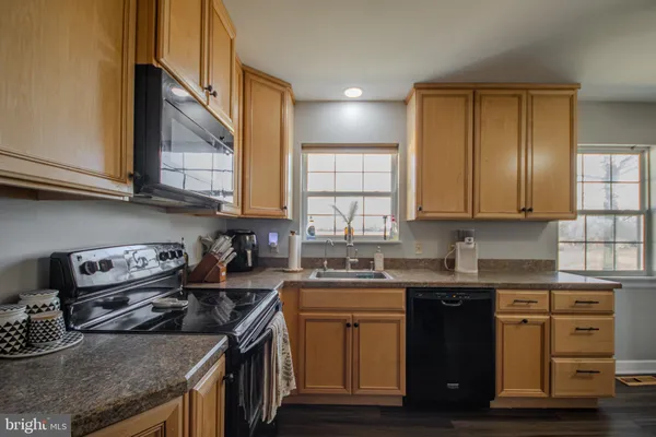 a kitchen with stainless steel appliances granite countertop a sink stove and cabinets