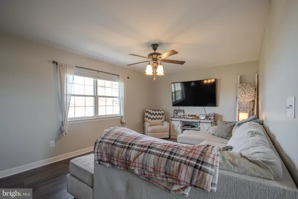 a living room with furniture a flat screen tv and a window
