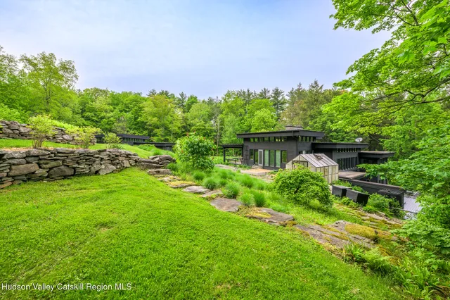 a view of a big house with plants and large trees