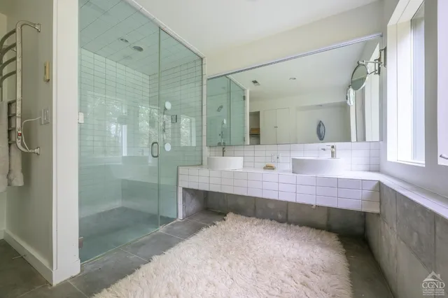 a view of a livingroom with furniture a book shelf and windows