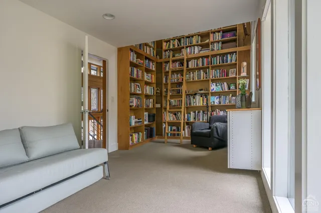 a living room with furniture a flat screen tv and a large window