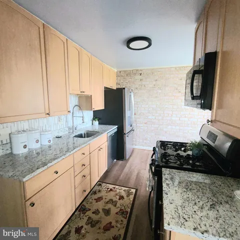 a kitchen with stainless steel appliances granite countertop a stove sink and cabinets