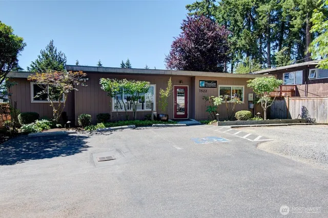 a front view of a house with garden and parking