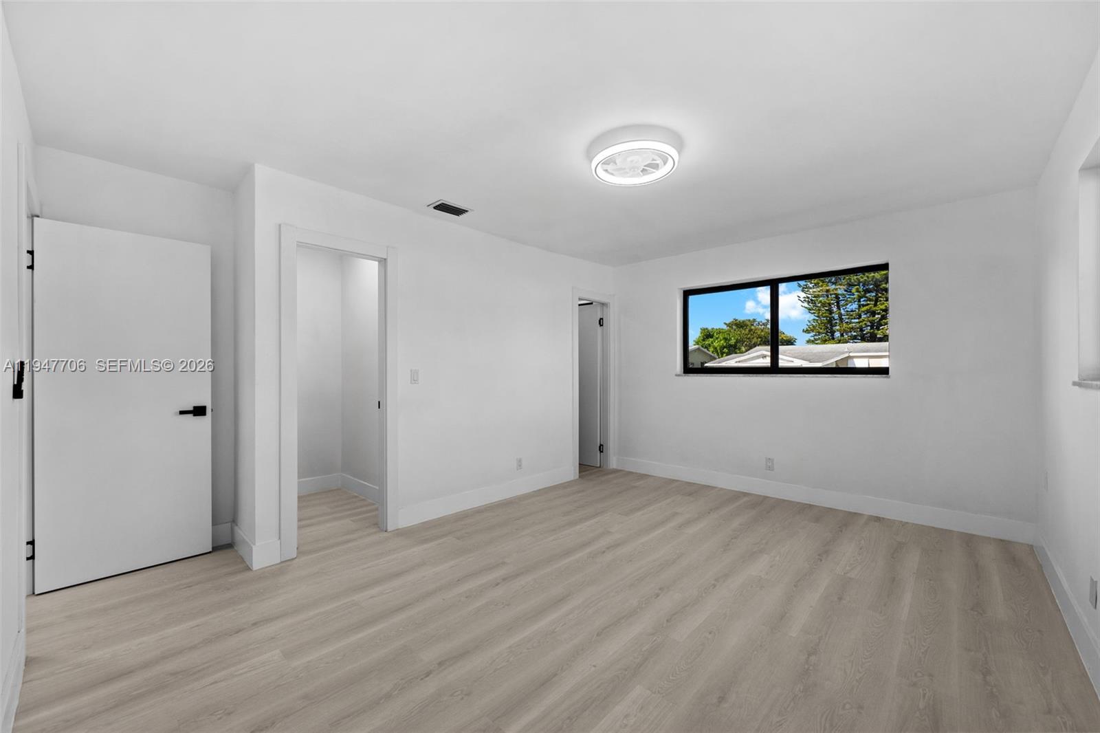 709 Southwest 4th Court Hallandale Beach, FL 33009 - Photo 22 of 59 an empty room with wooden floor and windows