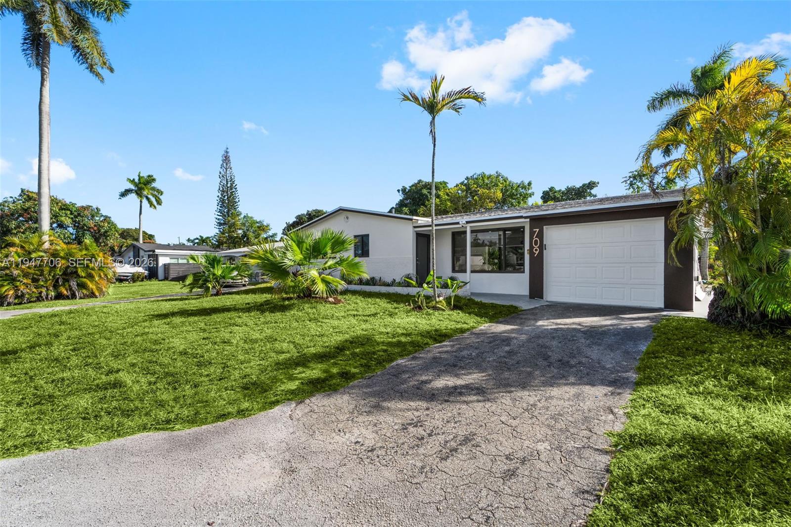 709 Southwest 4th Court Hallandale Beach, FL 33009 - Photo 38 of 59 a front view of a house with a yard and potted plants