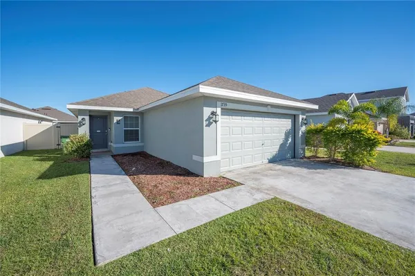 a front view of a house with a yard and garage