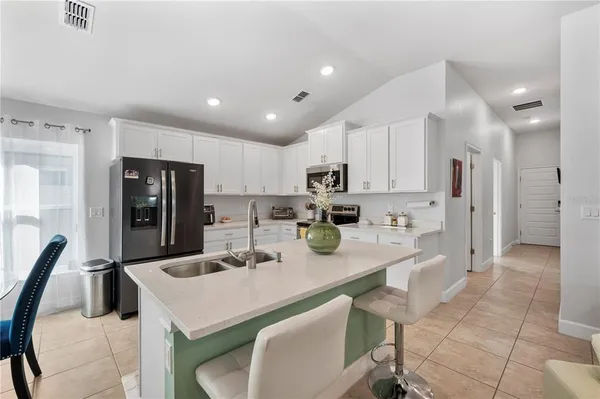 a kitchen with stainless steel appliances granite countertop a sink a stove a refrigerator and cabinets