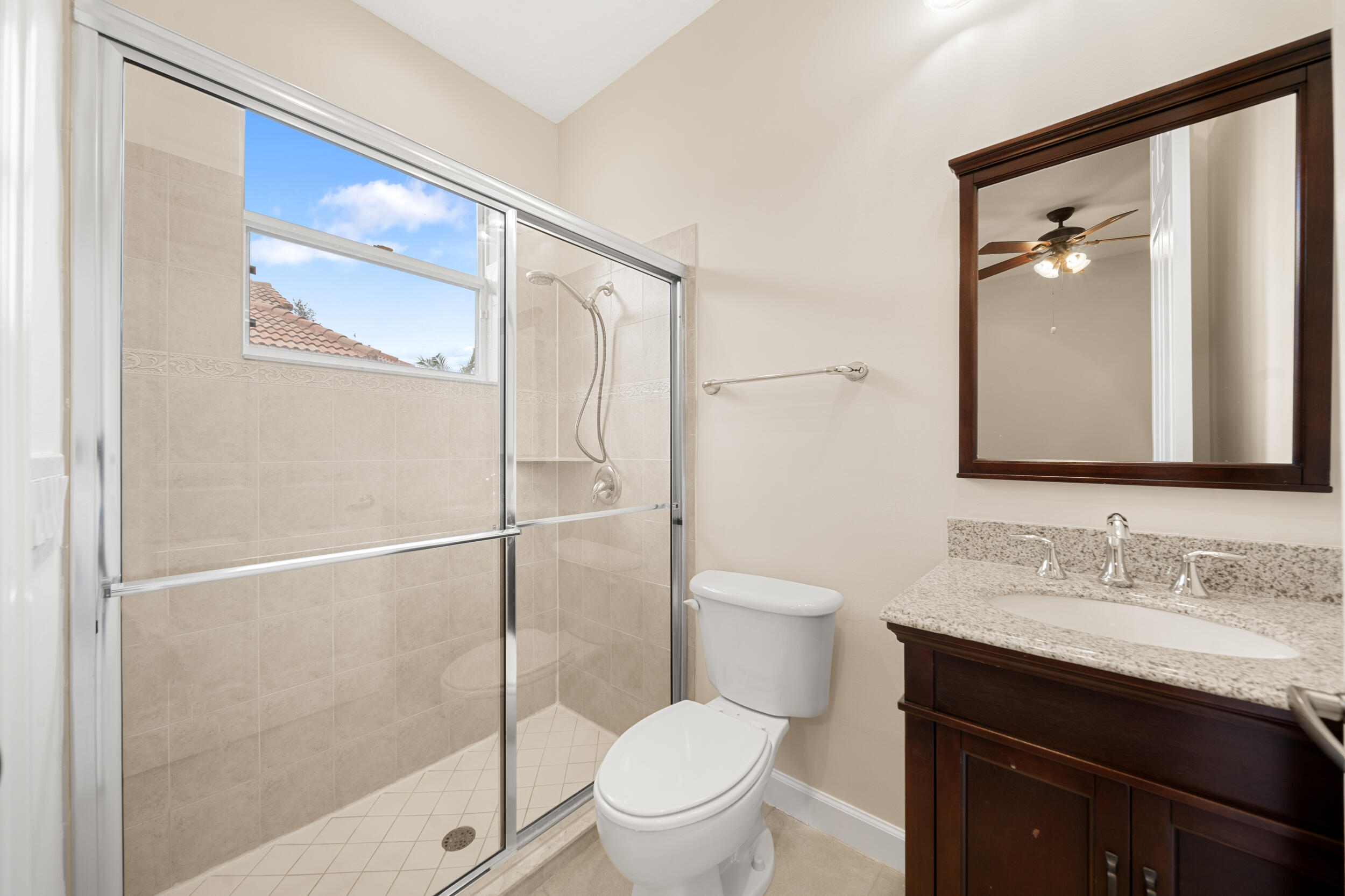 9004 Pumpkin Ridge Port St. Lucie, FL 34986 - Photo 12 of 36 a bathroom with a granite countertop sink toilet and shower