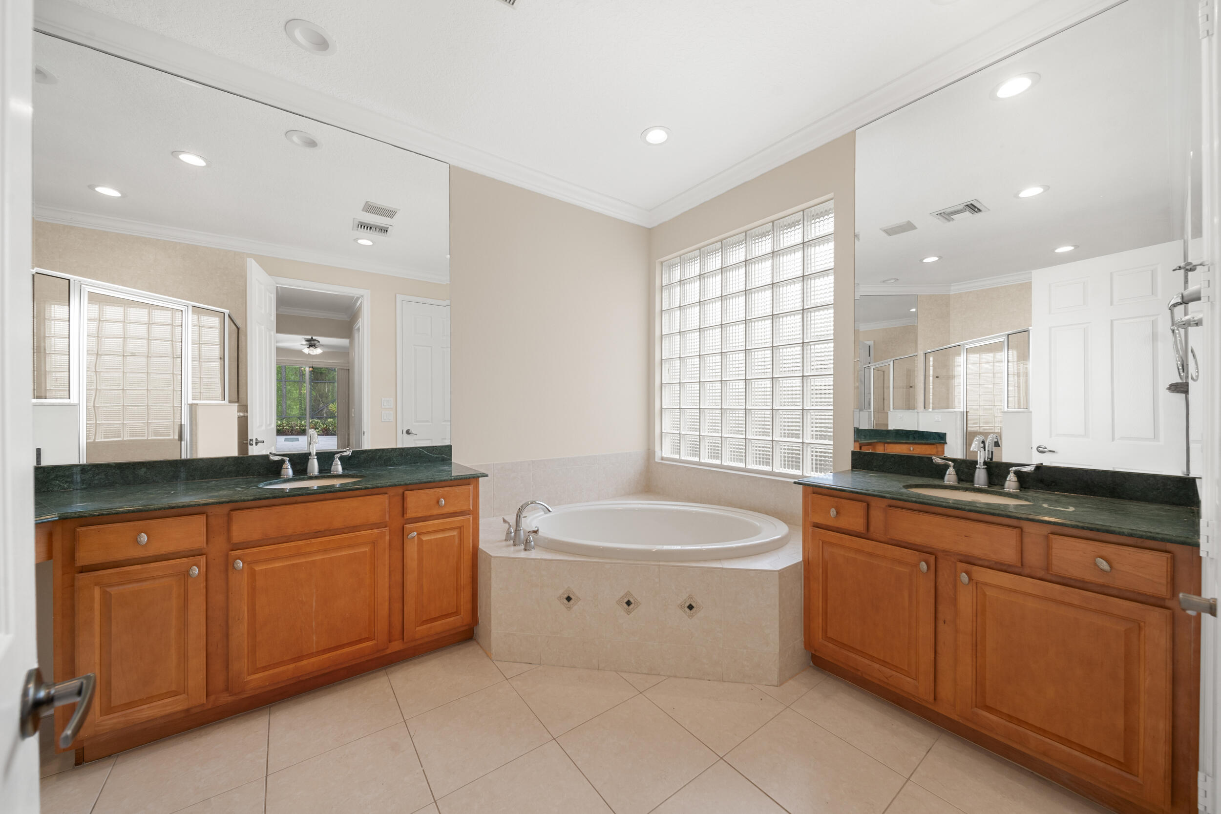 9004 Pumpkin Ridge Port St. Lucie, FL 34986 - Photo 18 of 36 a bathroom with a granite countertop double vanity sink a mirror and a bathtub