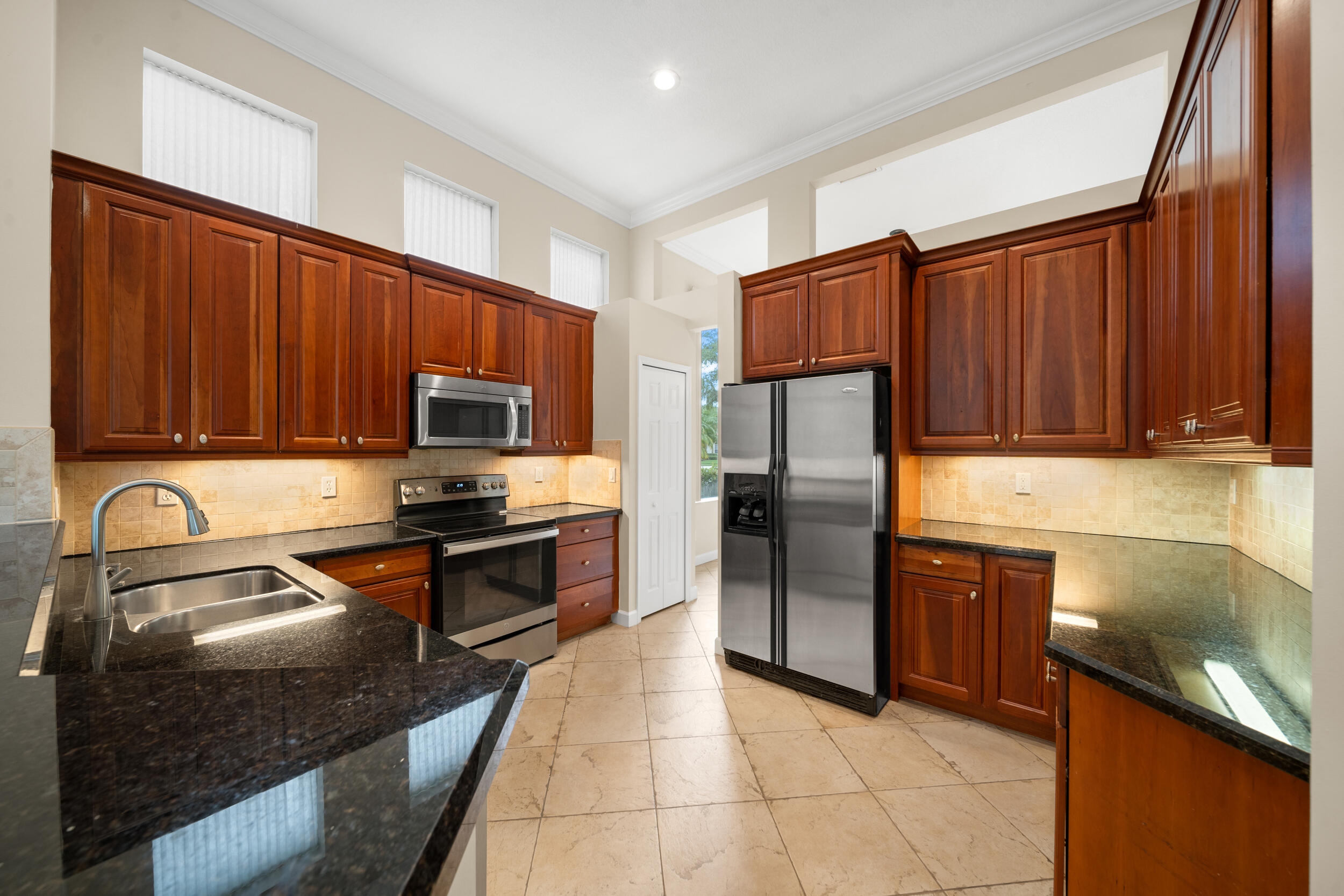 9004 Pumpkin Ridge Port St. Lucie, FL 34986 - Photo 29 of 36 a kitchen with granite countertop stainless steel appliances and wooden cabinets