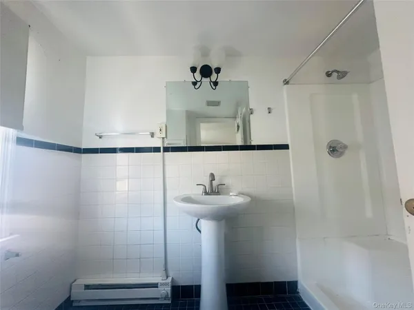 a bathroom with a sink mirror and shower