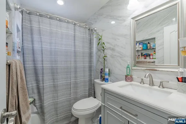 a bathroom with a granite countertop sink toilet and a mirror