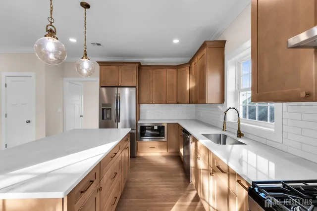 a kitchen with stainless steel appliances granite countertop a sink stove and refrigerator