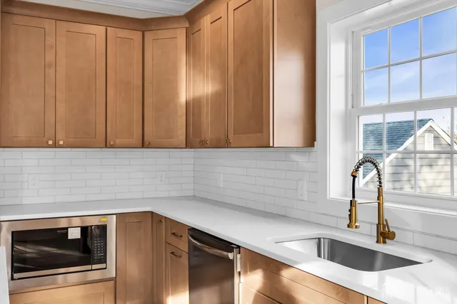 a kitchen with stainless steel appliances wooden cabinets a sink and a window