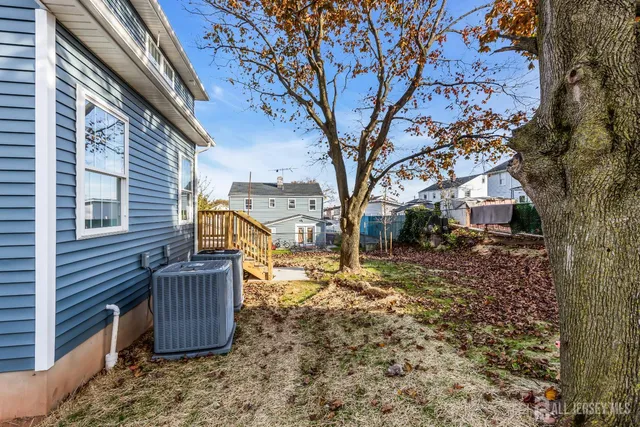 a view of a house with a large tree and a yard