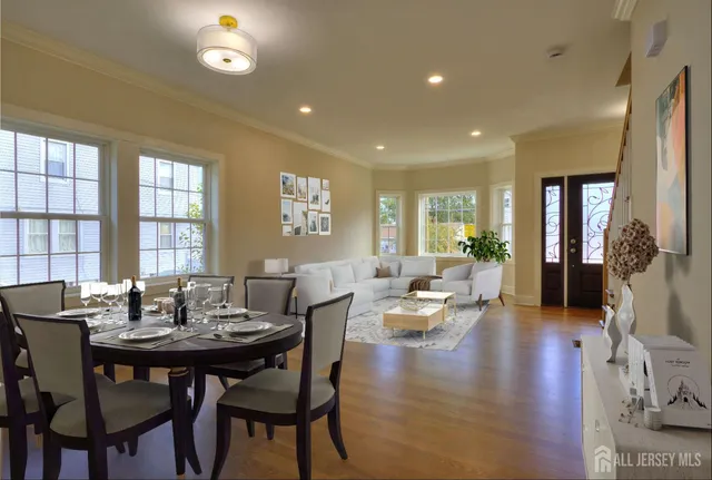a view of a dining room and livingroom with furniture wooden floor and a chandelier