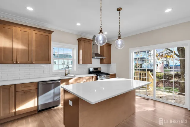 a kitchen that has a lot of cabinets a sink and wooden floor