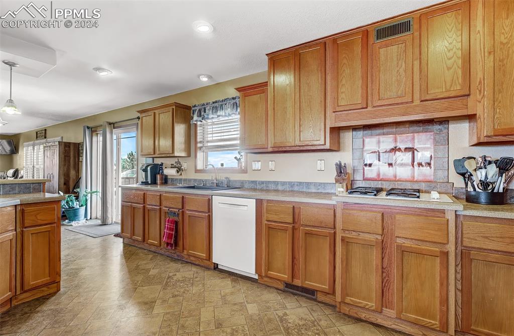 747 Harding Road Rush, CO 80833 - Photo 16 of 50 a kitchen with granite countertop a sink dishwasher stove and cabinets